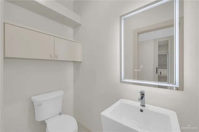 a bathroom with a toilet sink and mirror
