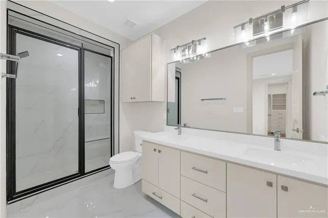 a bathroom with a double vanity sink mirror and toilet