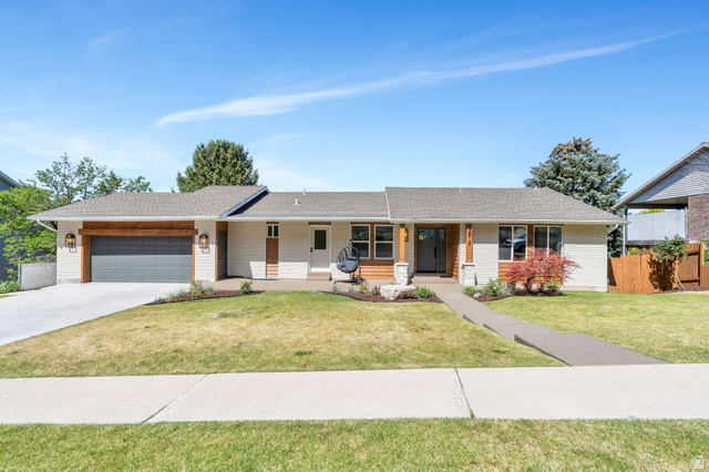 Ranch-style residence featuring a prominent two-car garage with a wood-finish header