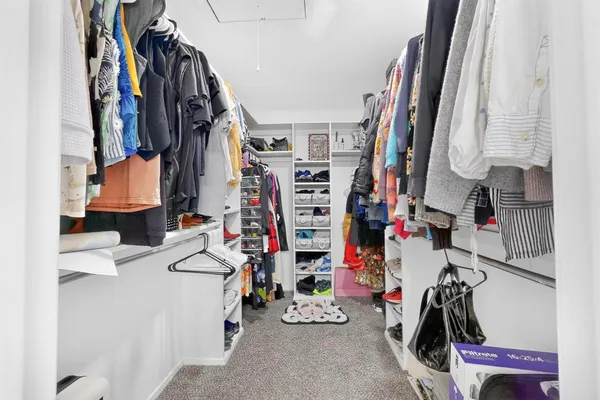 a view of walk in closet with clothes and shoes