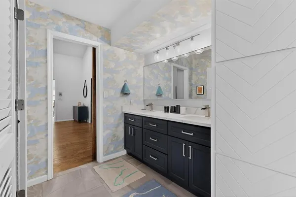 a bathroom with a double vanity sink and mirror with shower