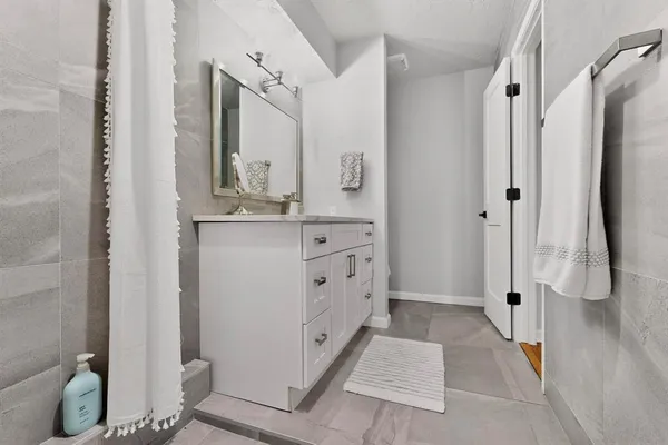 a bathroom with a double vanity sink toilet and shower