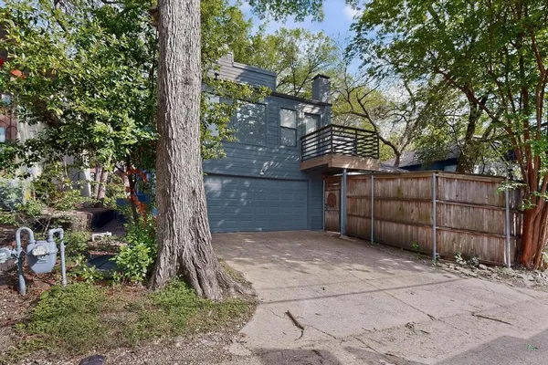 a view of backyard and wooden fence