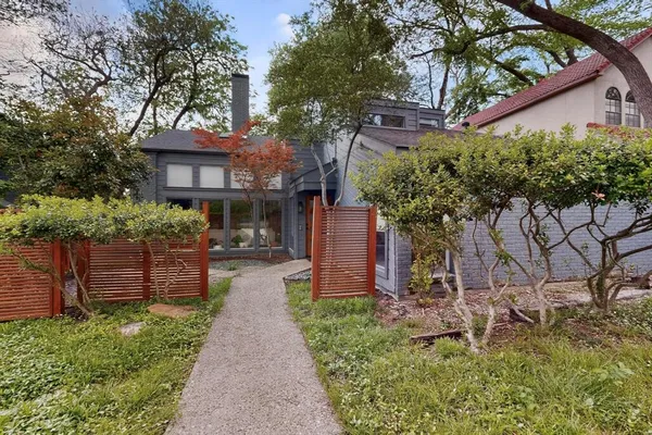 a front view of a house with a yard and potted plants