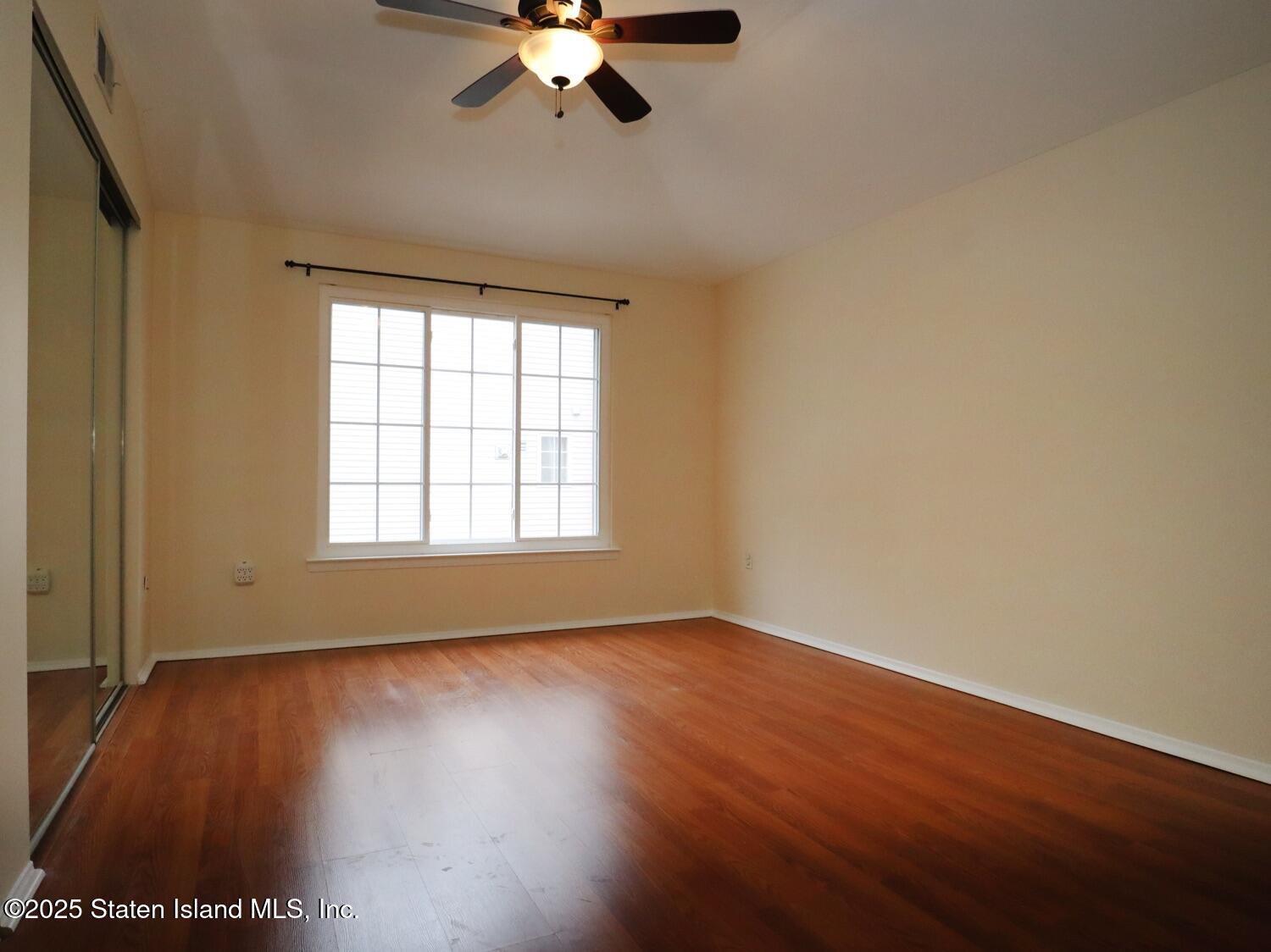 75 Chesebrough Street Staten Island, NY 10312 - Photo 12 of 32 a view of an empty room with wooden floor and a window