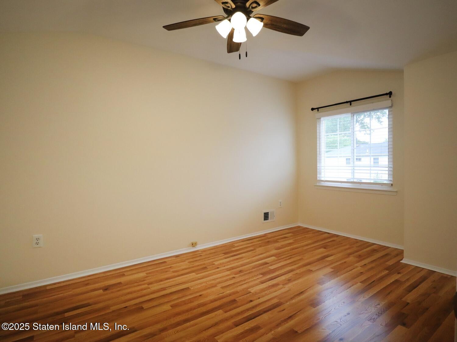 75 Chesebrough Street Staten Island, NY 10312 - Photo 20 of 32 a view of an empty room with wooden floor and a window