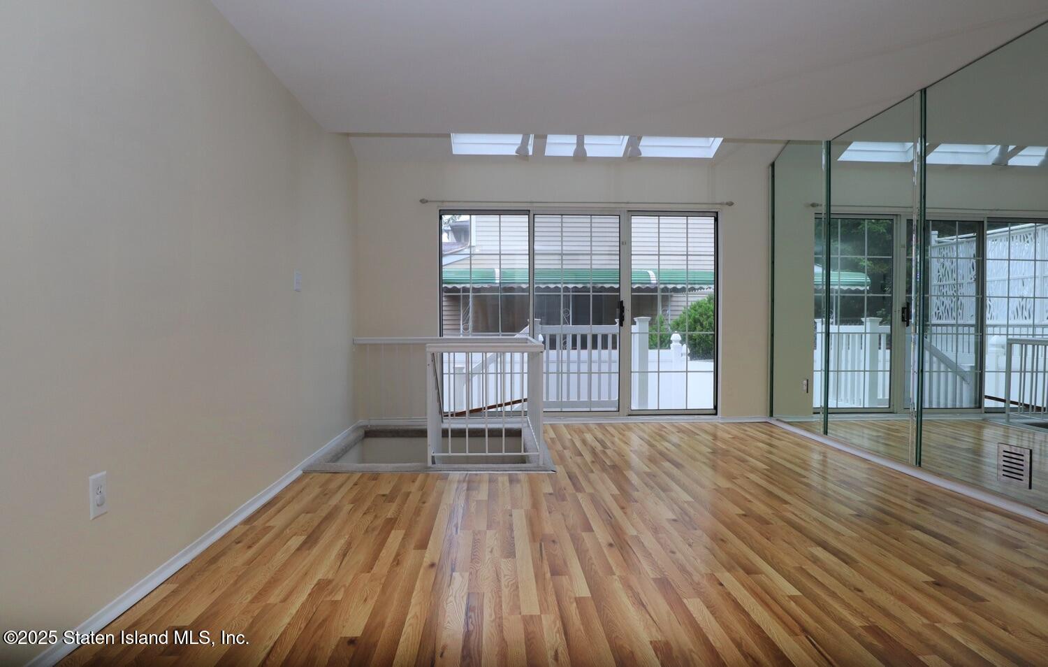 75 Chesebrough Street Staten Island, NY 10312 - Photo 5 of 32 en empty room with wooden floor and windows