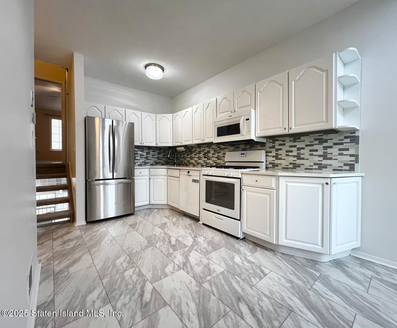 75 Chesebrough Street Staten Island, NY 10312 - Photo 8 of 32 a kitchen with white cabinets and stainless steel appliances