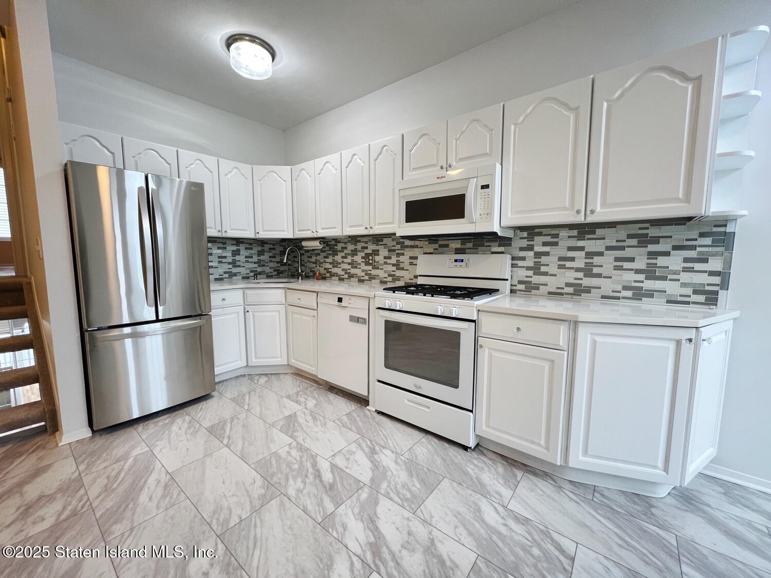 75 Chesebrough Street Staten Island, NY 10312 - Photo 9 of 32 a kitchen with white cabinets white stainless steel appliances and sink