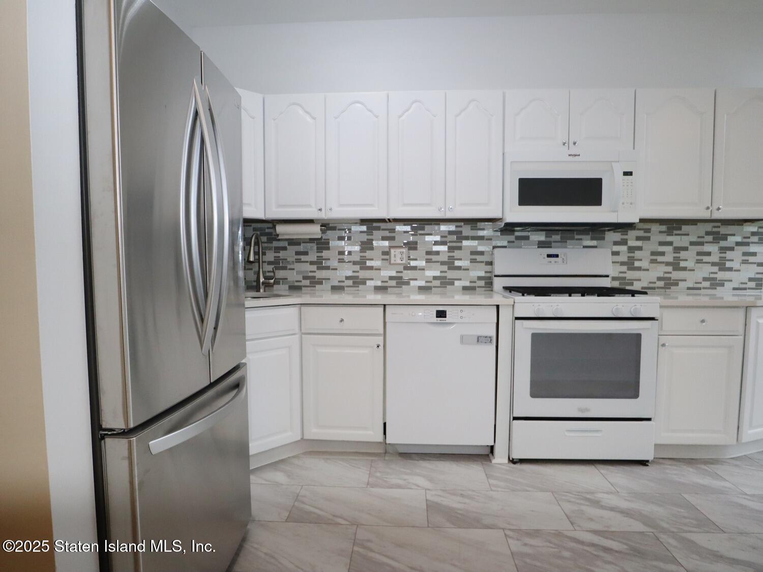 75 Chesebrough Street Staten Island, NY 10312 - Photo 10 of 32 a kitchen with granite countertop white cabinets and stainless steel appliances