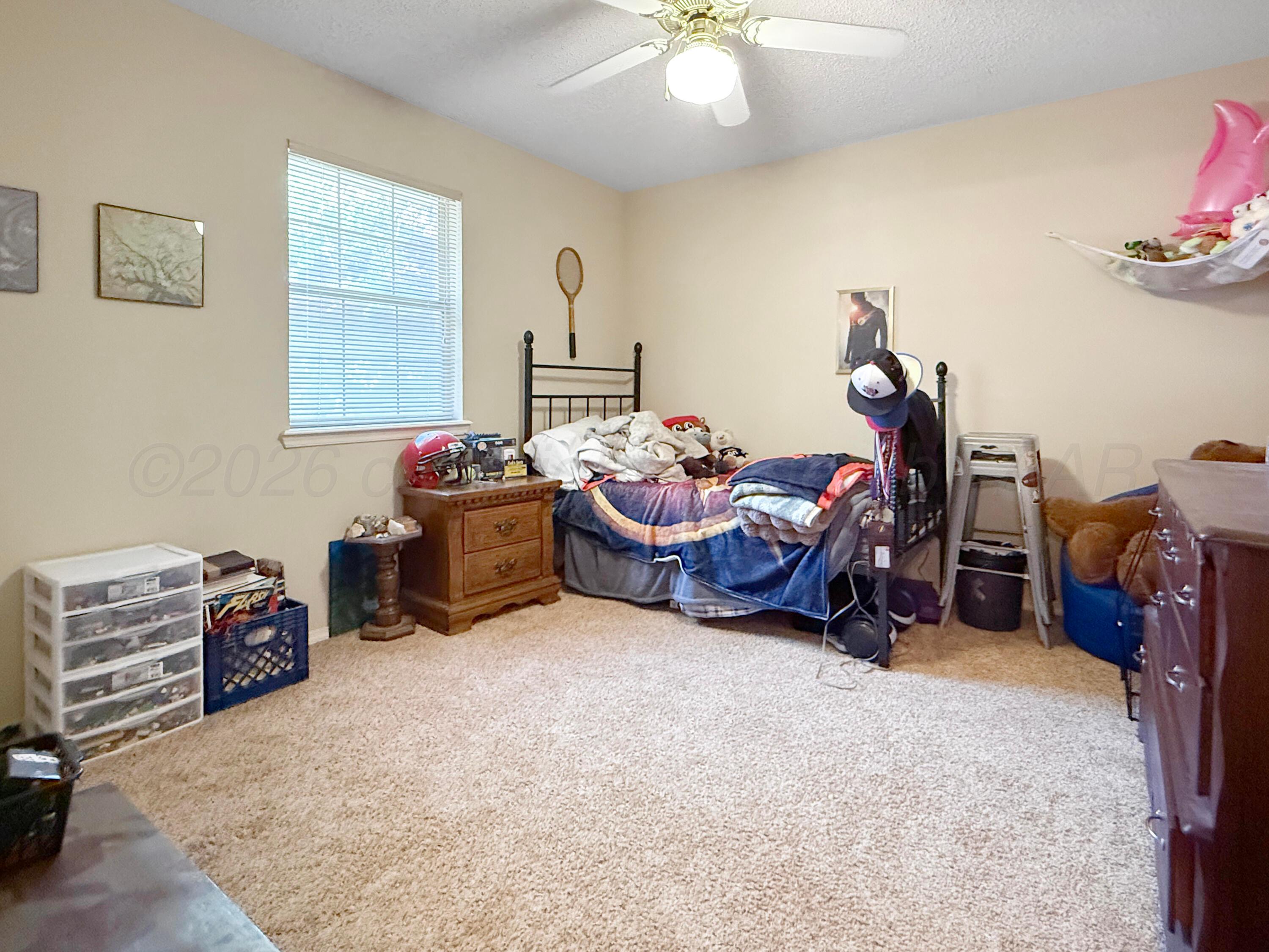 218 West Ocla Street Borger, TX 79007 - Photo 12 of 37 a bedroom with furniture and a chandelier