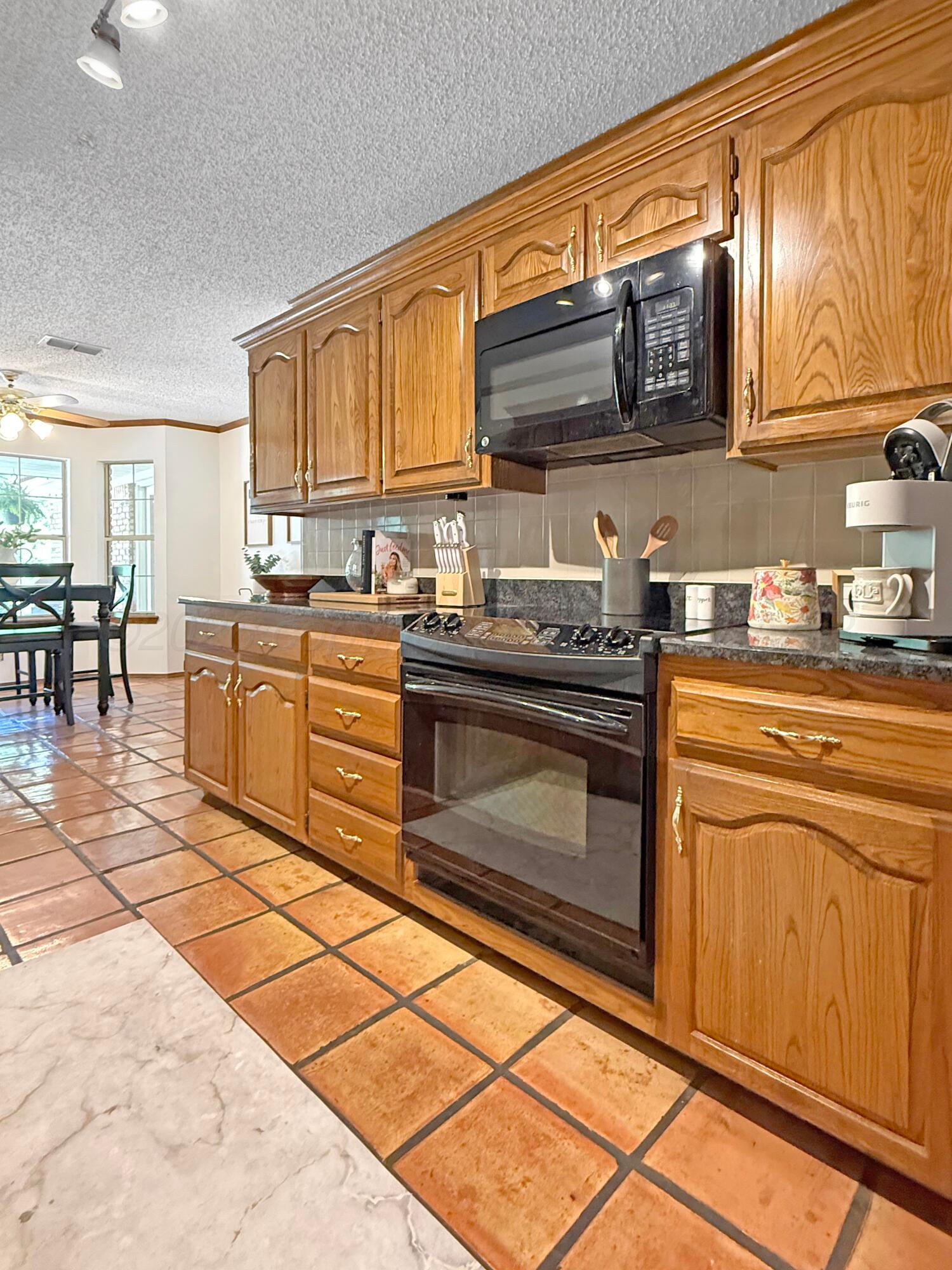 218 West Ocla Street Borger, TX 79007 - Photo 19 of 37 a kitchen with stainless steel appliances granite countertop a stove a sink and a microwave