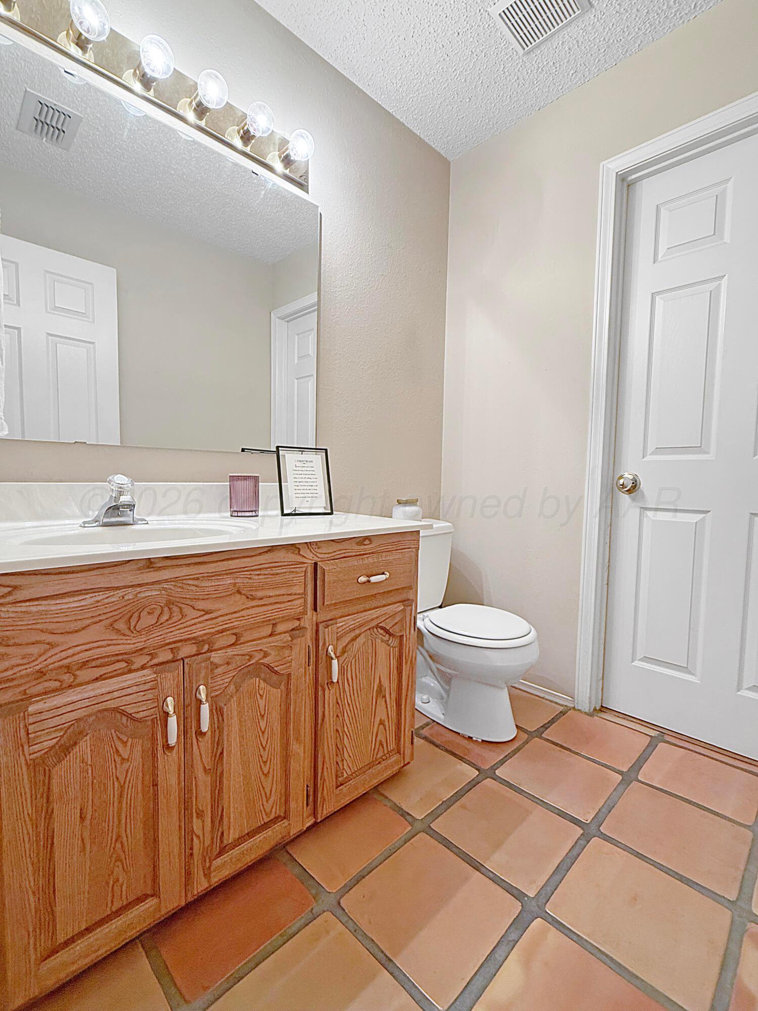 218 West Ocla Street Borger, TX 79007 - Photo 27 of 37 a spacious bathroom with a double vanity sink a toilet and a mirror