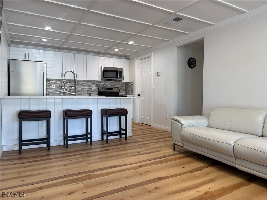5330 Treetops Drive, Unit F4 Naples, FL 34113 - Photo 9 of 9 a living room with furniture and a wooden floor