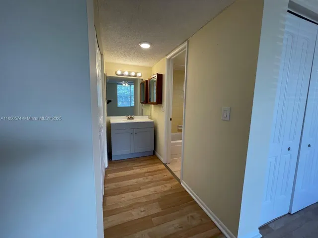 a view of a hallway with wooden floor and windows
