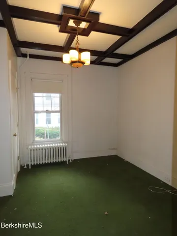 a view of a room with a ceiling fan and carpet