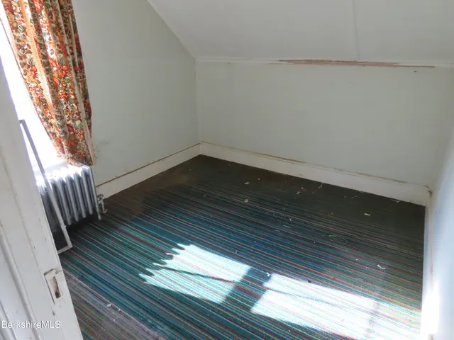 a view of a room with wooden floor and white walls