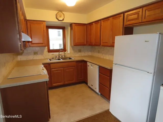 a kitchen with a sink a stove and a refrigerator