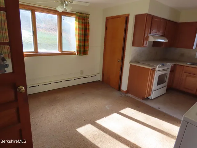 a view of a kitchen with stainless steel appliances wooden floor and a window