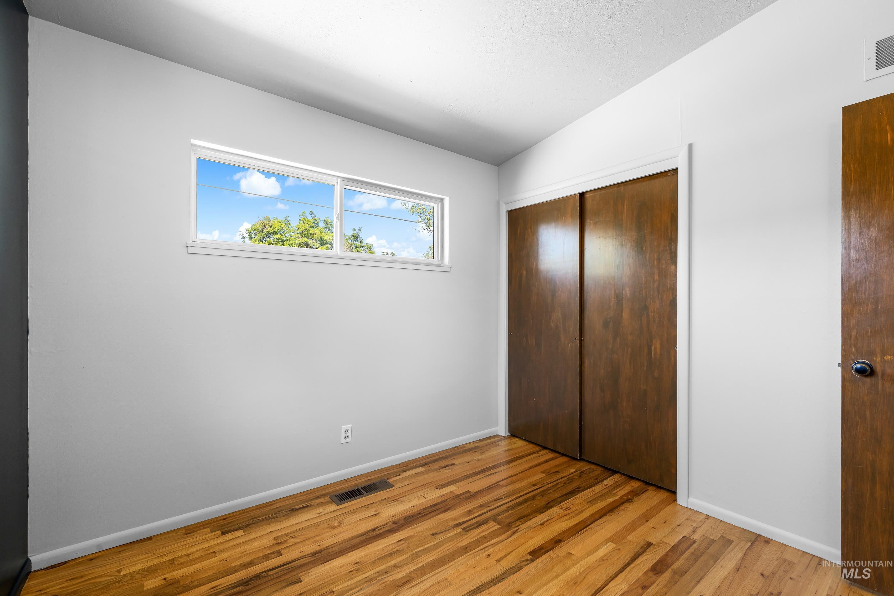 708 South Phillippi Street Boise, ID 83705 - Photo 16 of 25 Room featuring wood-finish flooring, a double sliding-door closet, and light gray painted walls