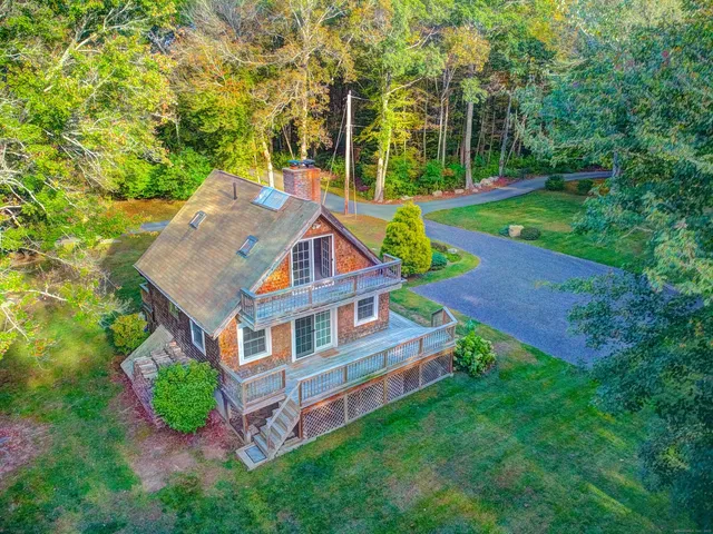 an aerial view of a house with swimming pool next to a big yard