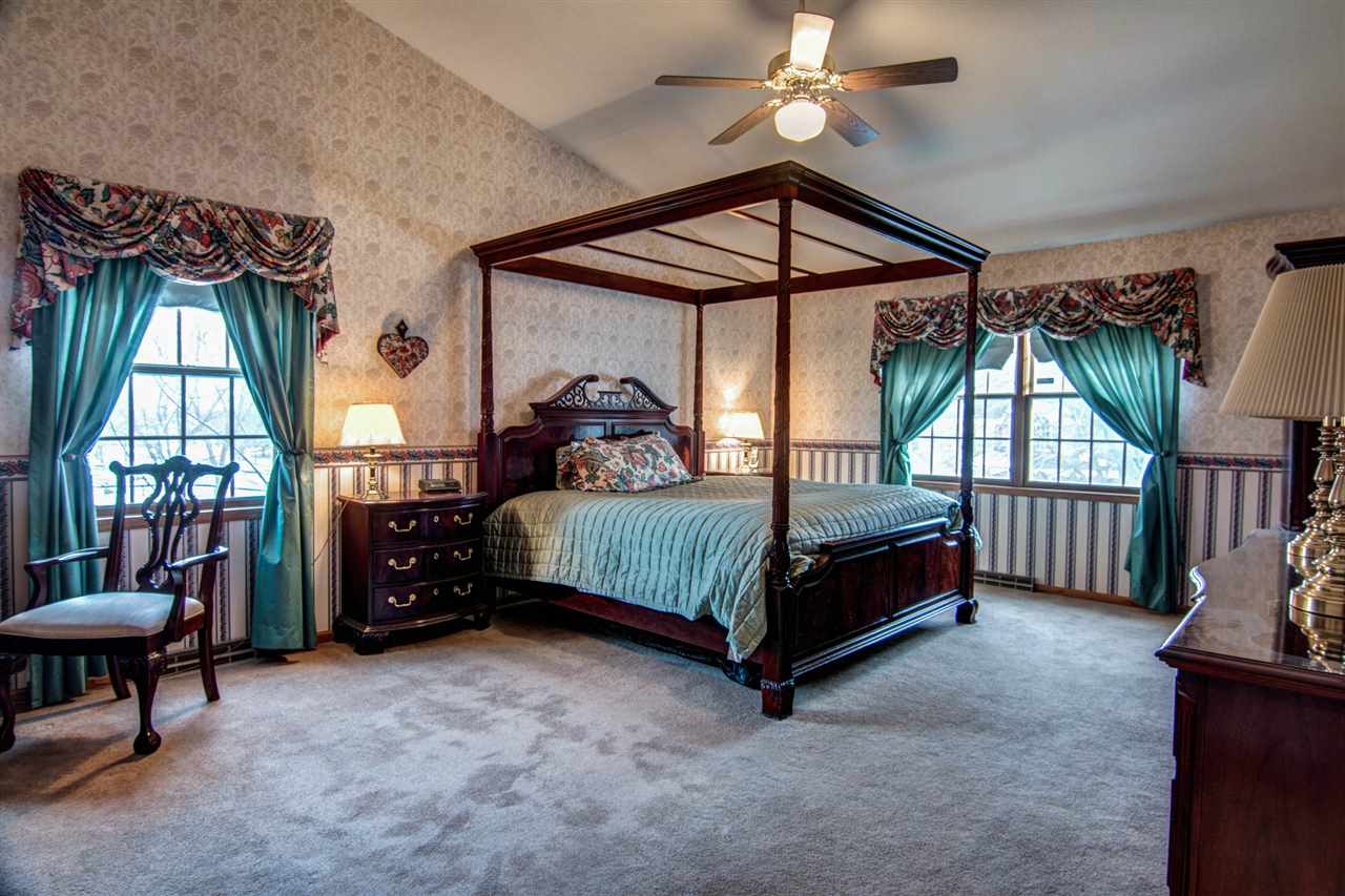 7196 Sentinel Road Rockford, IL 61107 - Photo 13 of 24 a bedroom with a bed a chandelier and a window
