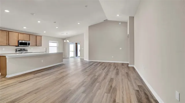 a view of kitchen with kitchen island microwave and cabinets