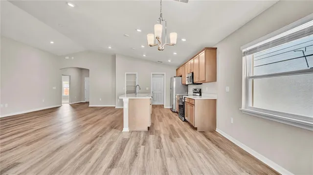 a kitchen with stainless steel appliances granite countertop a sink stove and wooden floor