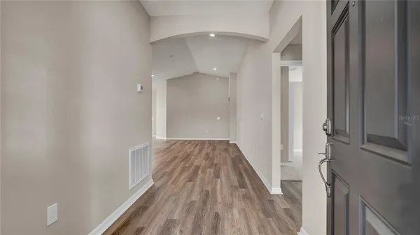 a view of a hallway with wooden floor and staircase