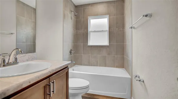 a bathroom with a granite countertop sink a toilet and bathtub