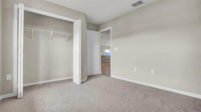 an empty room with windows and closet