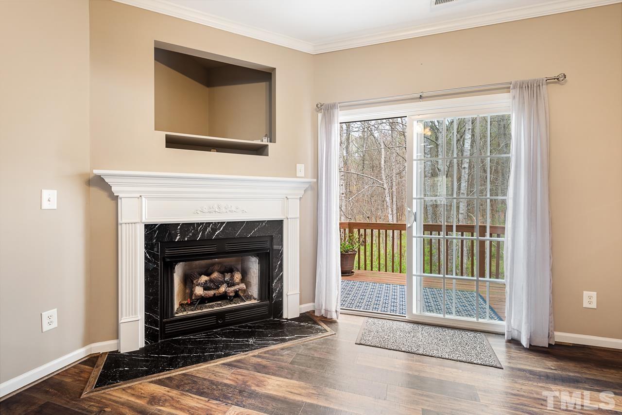 7892 Spungold Street Raleigh, NC 27617 - Photo 17 of 45 a living room with a fireplace and a floor