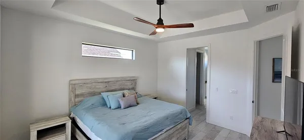 a bedroom with a table and ceiling fan