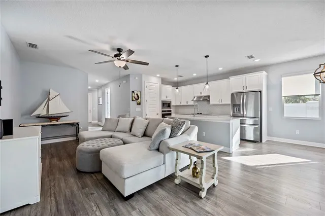 a living room with furniture and a wooden floor