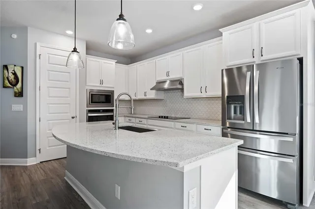 a kitchen with stainless steel appliances a refrigerator sink and microwave