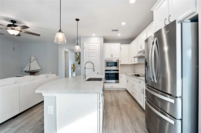 a large white kitchen with a stove top oven