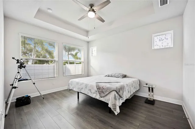 a bedroom with a bed and a large window with wooden floor