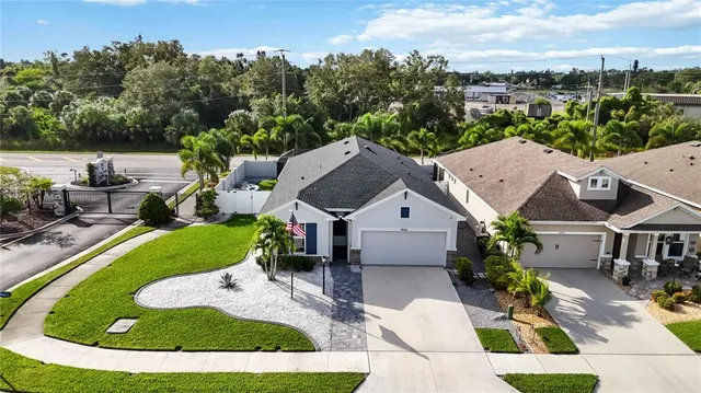 an aerial view of a city with lots of residential buildings ocean and mountain view in back