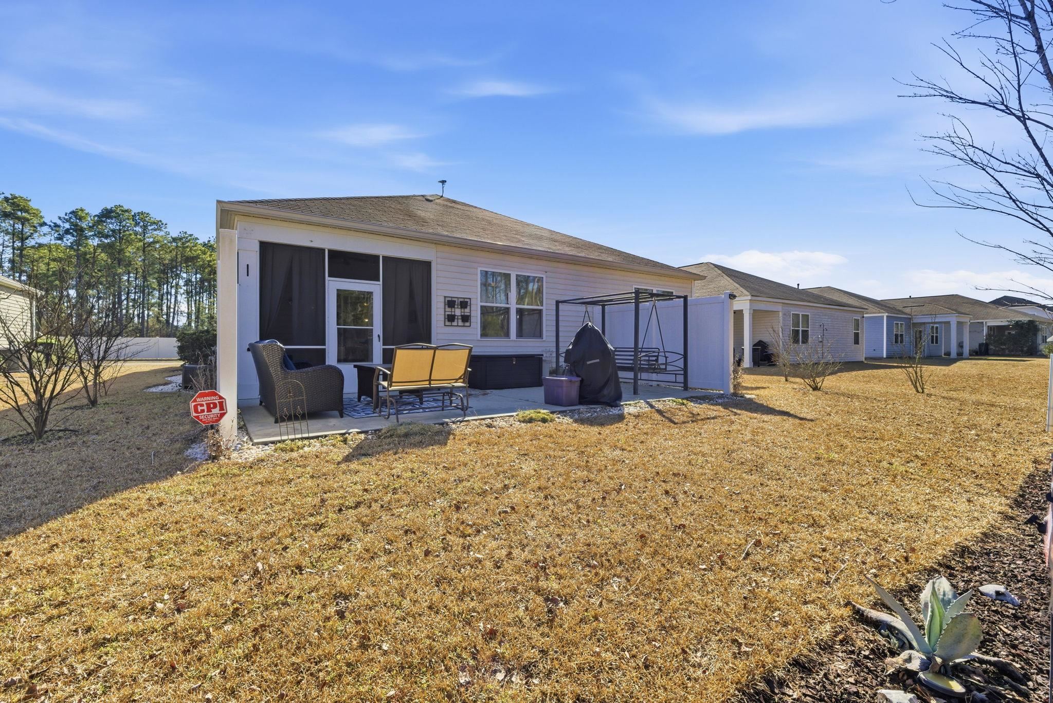 144 Legends Village Loop Myrtle Beach, SC 29579 - Photo 20 of 25 Rear view of house featuring a patio area, a yard, and a sunroom