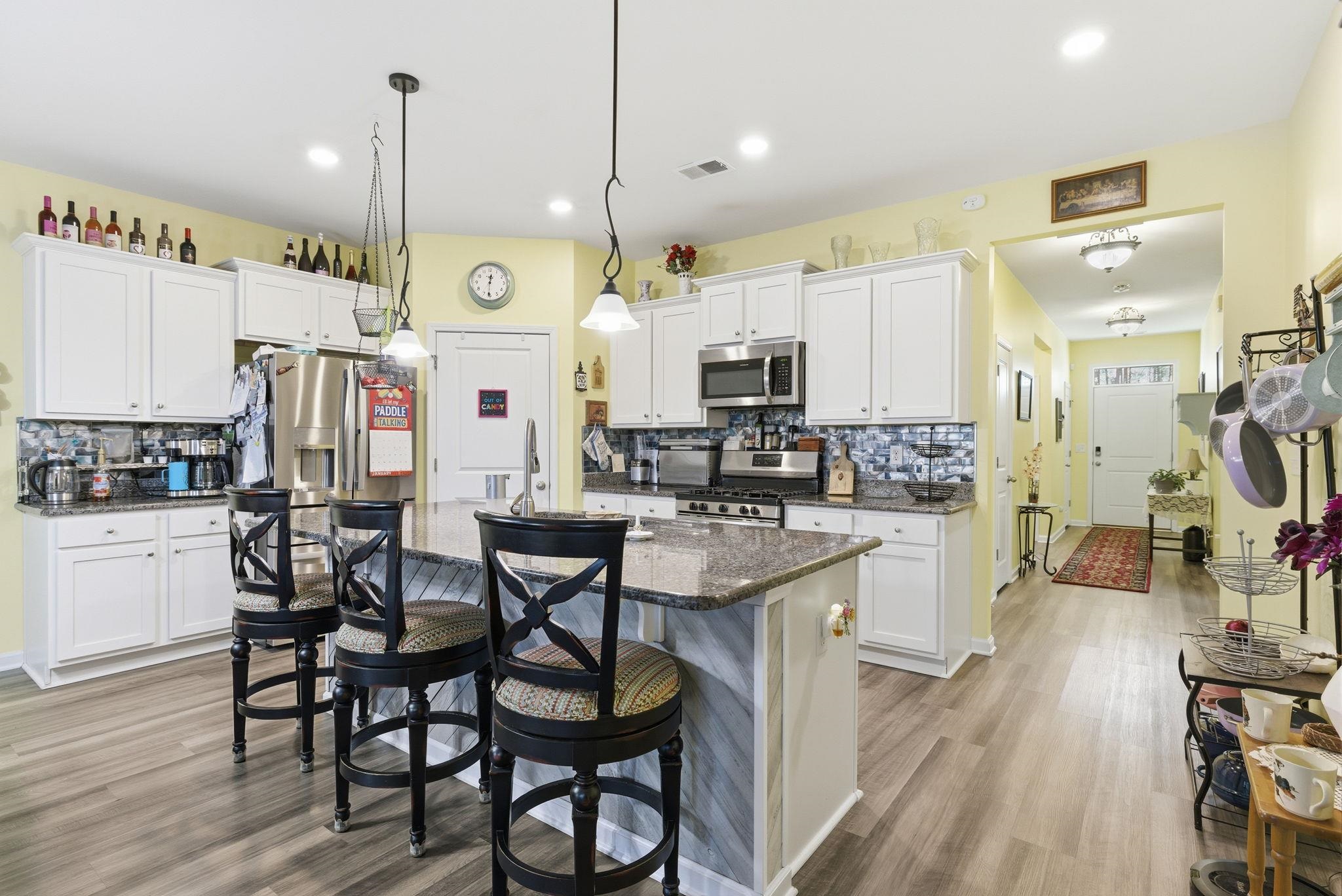 144 Legends Village Loop Myrtle Beach, SC 29579 - Photo 2 of 25 Kitchen featuring backsplash, white cabinets, appliances with stainless steel finishes, an island with sink, and recessed lighting