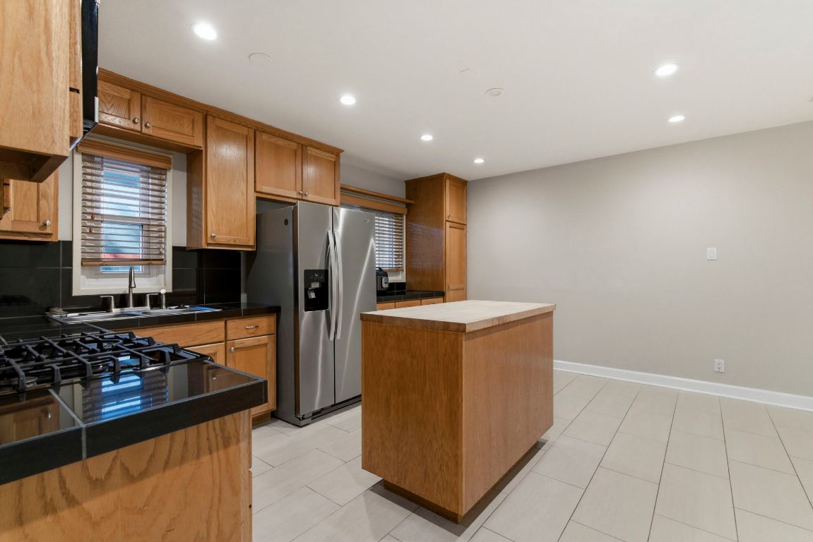 1504 West 39th 1/2 Street Austin, TX 78756 - Photo 7 of 23 a kitchen with stainless steel appliances granite countertop a refrigerator and a stove