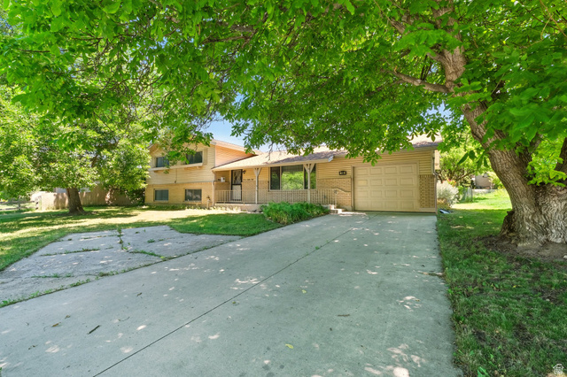 1188 600 East Logan, UT 84341 - Photo 2 of 16 Tri-level home with a front yard, driveway, brick siding, and a garage