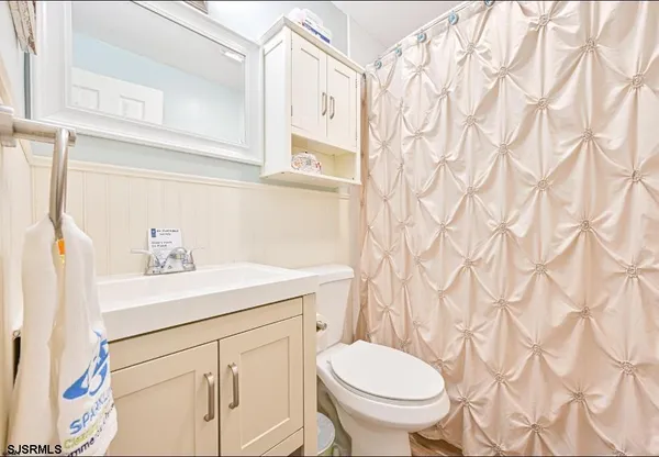a bathroom with a sink a toilet and a mirror