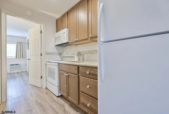 a kitchen with white cabinets and sink