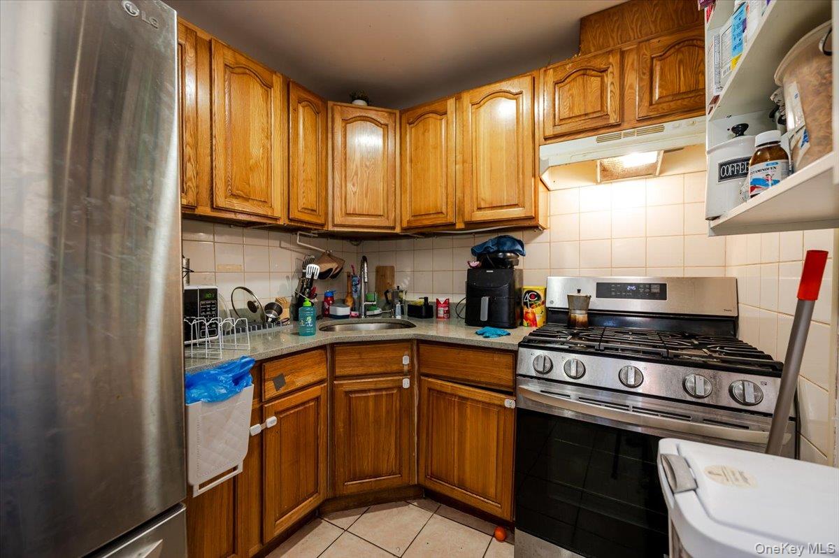 10010 133rd Avenue Queens, NY 11417 - Photo 15 of 22 a kitchen with stainless steel appliances granite countertop a stove a sink dishwasher and cabinets with wooden floor