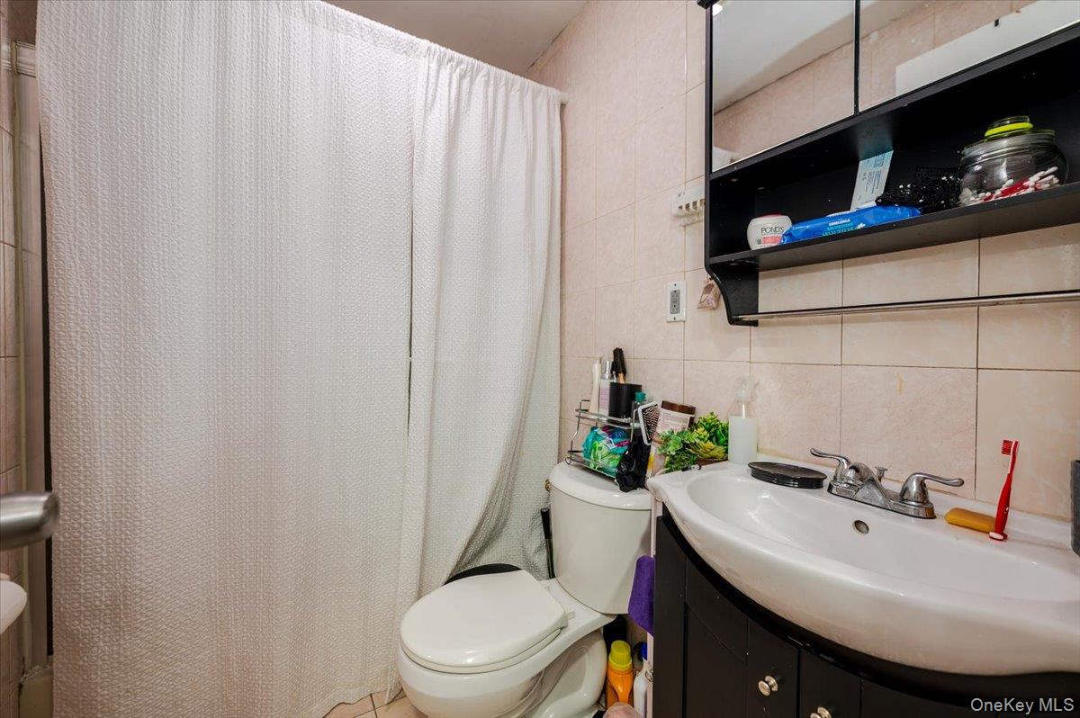 10010 133rd Avenue Queens, NY 11417 - Photo 18 of 22 a bathroom with a sink a toilet and a mirror