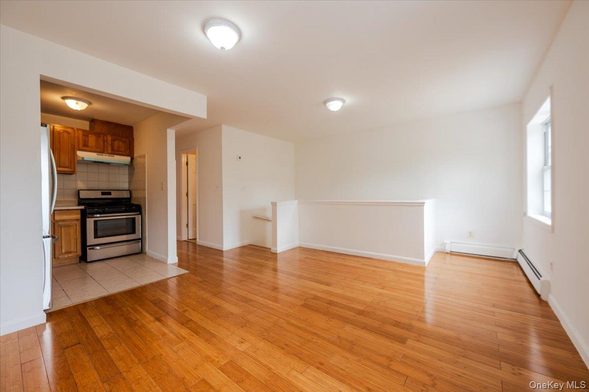 10010 133rd Avenue Queens, NY 11417 - Photo 4 of 22 a view of empty room with wooden floor and kitchen