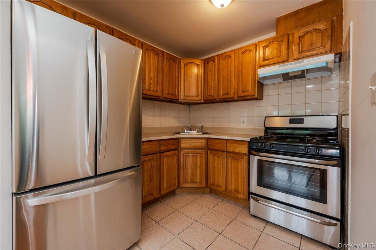 10010 133rd Avenue Queens, NY 11417 - Photo 5 of 22 a kitchen with stainless steel appliances granite countertop a refrigerator stove and sink