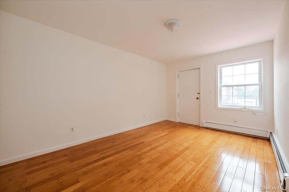 10010 133rd Avenue Queens, NY 11417 - Photo 9 of 22 wooden floor in an empty room with a window