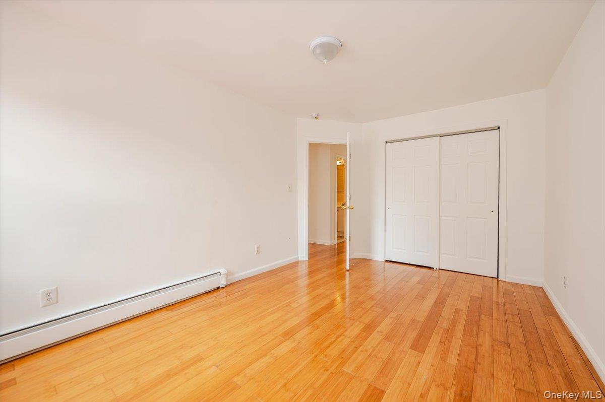 10010 133rd Avenue Queens, NY 11417 - Photo 10 of 22 a view of an empty room with wooden floor and a window